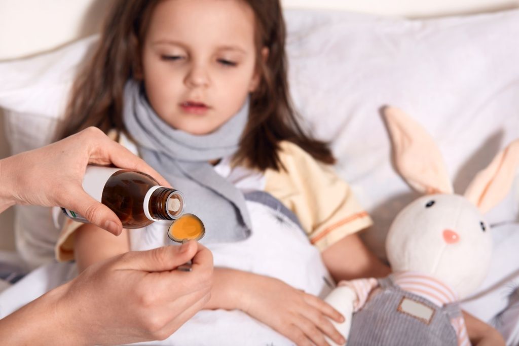 horizontal-photo-unknown-hand-pouring-liquid-into-spoon-from-little-bottle-with-syrup-person-caring-about-child-lying-bed-with-flu (1).jpg